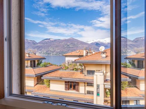 une fenêtre avec vue sur l'eau et les montagnes dans l'établissement Apartment Giulia by Interhome, à Luino