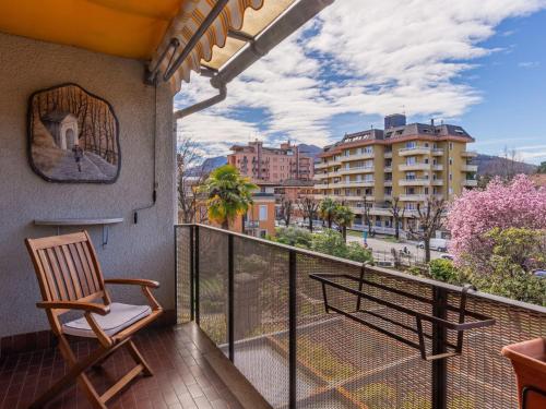 d'un balcon avec une chaise et une vue sur la ville. dans l'établissement Apartment Giulia by Interhome, à Luino