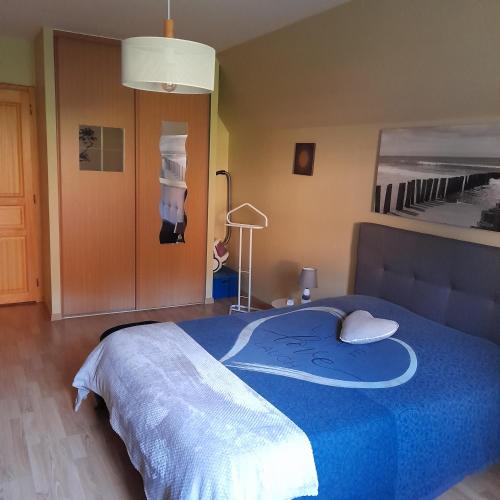 une chambre avec un lit avec une couette bleue dans l'établissement Le coin des oiseaux, à Carsac-Aillac