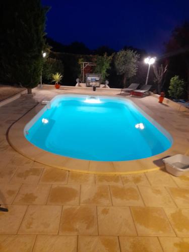 une piscine dans un jardin la nuit dans l'établissement Le coin des oiseaux, à Carsac-Aillac