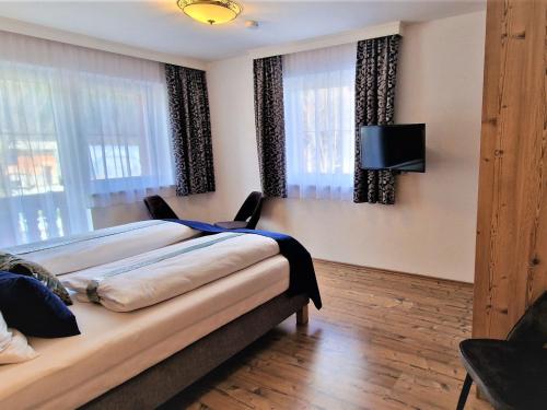 a bedroom with a bed and a flat screen tv at Apartment Apartment Emberg by Interhome in Aschau