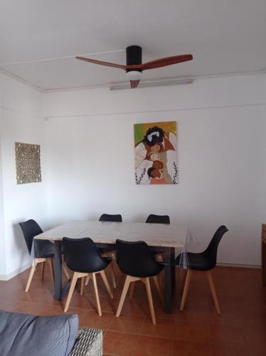 - une table à manger avec des chaises et un ventilateur de plafond dans l'établissement Appartement Cosy, à Beau Bassin-Rose Hill
