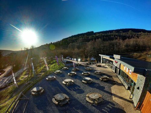 eine Gruppe von Autos, die auf einem Parkplatz neben einem Gebäude geparkt sind in der Unterkunft Mount Pleasant Retreat in Troed-y-rhiw