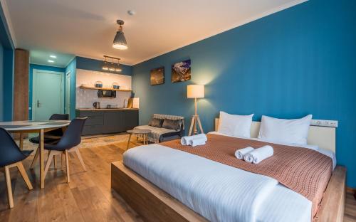 a bedroom with a large bed and a table at New Gudauri Apartments in Atrium in Gudauri