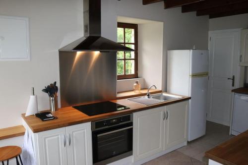 une cuisine avec un évier et une cuisinière four supérieur dans l'établissement 18th century Gite in spacious Private Grounds, à Notre-Dame-de-Cenilly