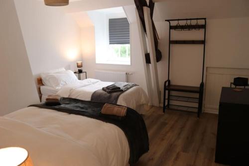 une chambre avec deux lits et une fenêtre dans l'établissement 18th century Gite in spacious Private Grounds, à Notre-Dame-de-Cenilly