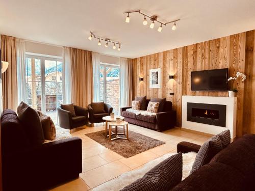 a living room with leather furniture and a fireplace at Sonn-Alm Chalet-Apartments in Bichlbach