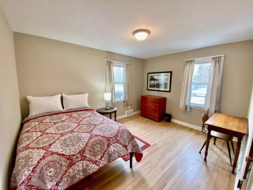 1 dormitorio con 1 cama, escritorio y 2 ventanas en Outpatient Cleve Clinic with Fenced-In Backyard, en Cleveland Heights