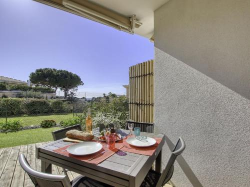 einen Tisch mit Teller mit Speisen auf einer Terrasse in der Unterkunft Apartment Les Terrasses d'Azur-2 by Interhome in Sanary-sur-Mer