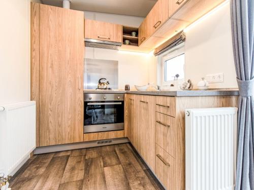 - une cuisine avec des placards en bois et une cuisinière dans l'établissement Holiday Home Tiny Haus Martina by Interhome, à Beilngries