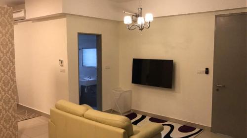 a living room with a couch and a flat screen tv at Hyve in Cyberjaya