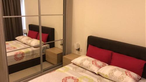 um quarto com um espelho e uma cama com almofadas vermelhas em Hyve em Cyberjaya