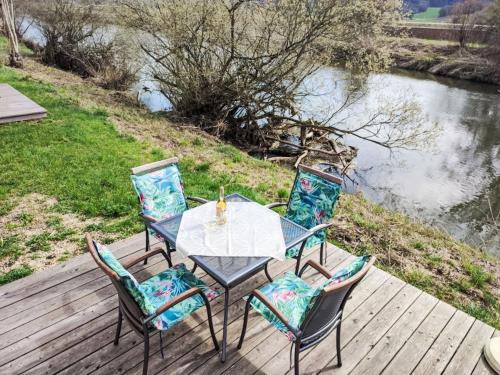 una mesa y cuatro sillas en una terraza junto a un río en Holiday Home Tiny Haus Altmühlblick by Interhome en Beilngries