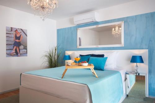 a blue and white bedroom with a bed with a table at Monvidal by Bura Hotels - Adults Only in Pula