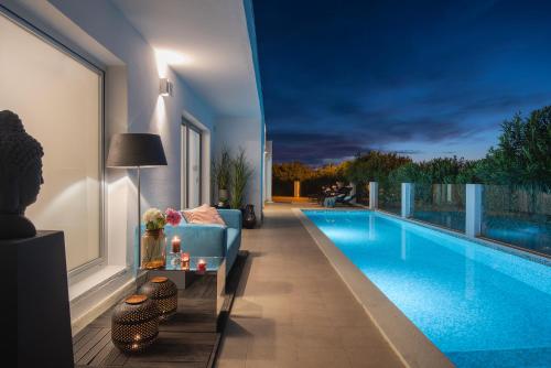 een woonkamer met een blauwe bank naast een zwembad bij Monvidal Residence - Adults Only in Pula