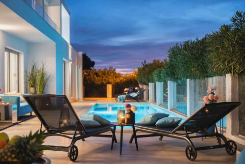 twee stoelen en een tafel naast een zwembad bij Monvidal Residence - Adults Only in Pula