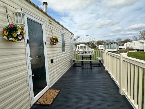 a wooden deck with a table on a house at A Beautiful Dog Friendly Holiday Home in Mablethorpe