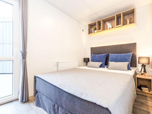 a bedroom with a large bed with blue pillows at Holiday Home Tiny Haus Ingrid by Interhome in Beilngries