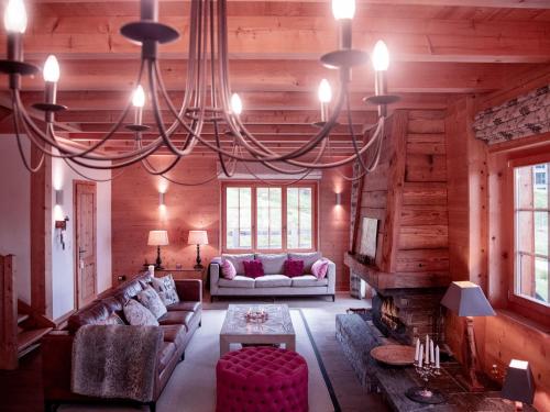 a large living room with a large chandelier at Chalet Chalet Olivier by Interhome in Villars-sur-Ollon