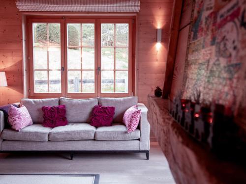 a couch with pillows in a room with a window at Chalet Chalet Olivier by Interhome in Villars-sur-Ollon