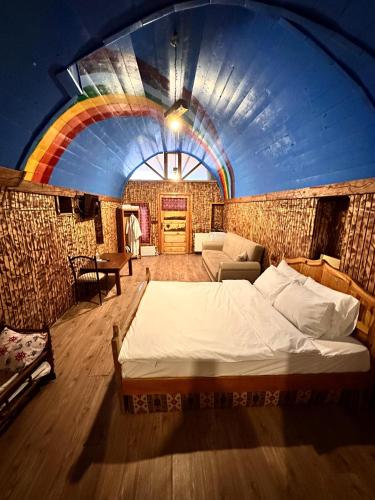 a bedroom with a bed in a room with a rainbow at Tokmak Konukevi in Avanos