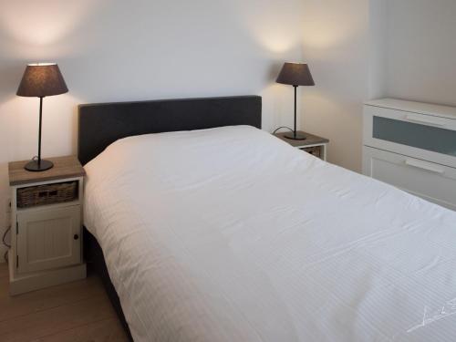 - une chambre avec un grand lit blanc et deux lampes dans l'établissement Apartment Key Point by Interhome, à Blankenberge