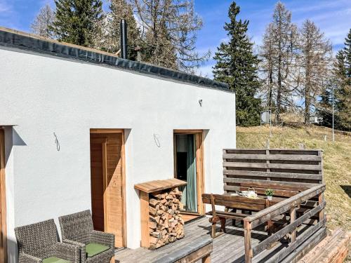 ein winziges Haus mit einer Terrasse und einer Bank in der Unterkunft Apartment Stieglitz by Interhome in Hochrindl