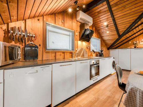 uma cozinha com armários brancos e um tecto de madeira em Holiday Home Tjana - all inclusive - 6km from the sea by Interhome em Esbjerg