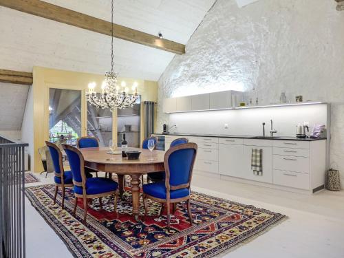 una sala da pranzo con tavolo e sedie su un tappeto di Apartment Winzerhaus by Interhome a Ligerz
