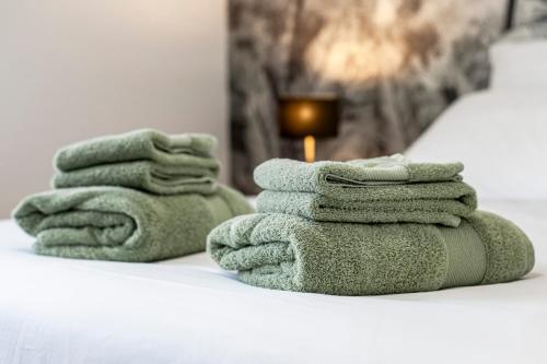 una pila de toallas sentadas encima de una cama en Le Clos de la Jouvence - Gite 4* à 15 minutes du Puy du Fou, 6 personnes en Saint-Laurent-sur-Sèvre