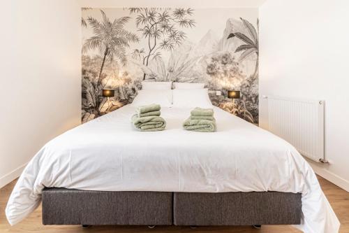 Un dormitorio con una cama blanca con toallas verdes. en Le Clos de la Jouvence - Gite 4* à 15 minutes du Puy du Fou, 6 personnes en Saint-Laurent-sur-Sèvre