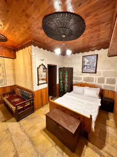 a bedroom with a bed and a bench in a room at Tokmak Konukevi in Avanos