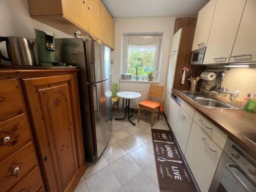 a kitchen with a refrigerator and a table in it at Casa Molto Bene in Velden am Wörthersee
