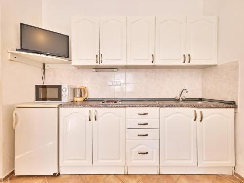 kuchnia z białymi szafkami i kuchenką mikrofalową w obiekcie Apartment Villa Belvedere-2 by Interhome w Jańskich Łaźniach