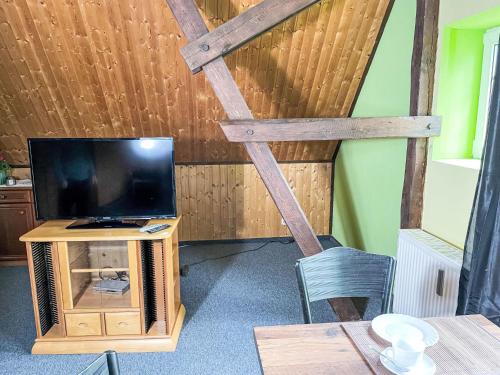 a living room with a tv and a wooden ceiling at Apartment Kranich by Interhome in Granzin