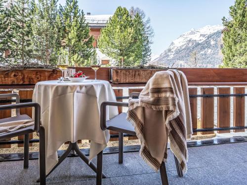a table and chairs on a balcony with a view of a mountain at Apartment Chesa Murtel by Interhome in Surlej