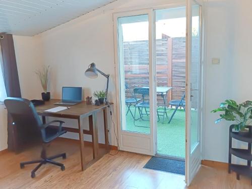 un bureau avec un bureau avec un ordinateur et une porte vitrée dans l'établissement 54m2 lumineux avec terrasse au cœur des Minimes métro, à Toulouse