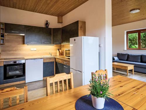 a kitchen with a table and a white refrigerator at Apartment Pod Černou Studnicí-3 by Interhome in Nova Ves nad Nisou