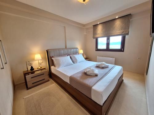 um quarto com uma cama grande e uma janela em Serenity Heights Ioannina em Neochorópoulon