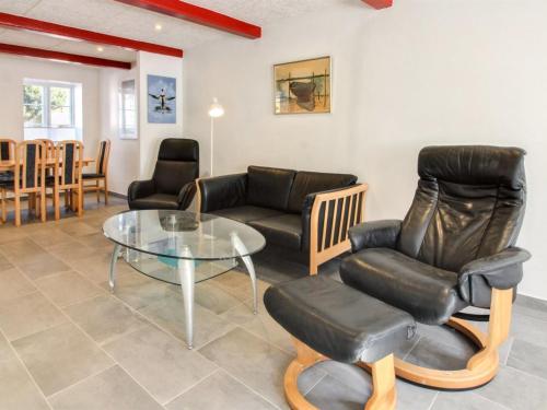 uma sala de estar com uma mesa de vidro e cadeiras em Holiday Home Odeta - all inclusive - 25km from the sea by Interhome em Højer