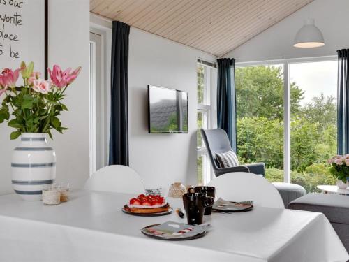 een witte eetkamer met een witte tafel en stoelen bij Holiday Home Jörgen - all inclusive - 100m from the sea by Interhome in Esbjerg