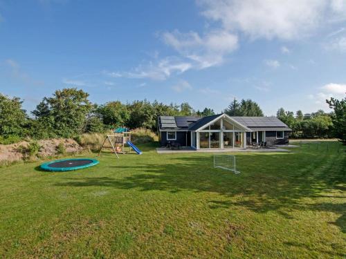 a house with a large yard with a playground at Holiday Home Talida - all inclusive - 12km from the sea by Interhome in Oksbøl
