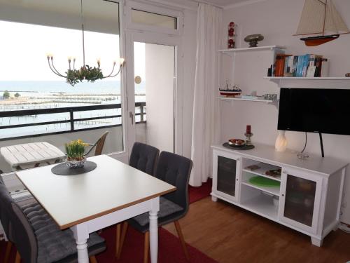 ダンプにあるApartment Ostsee-Residenz by Interhomeのテーブルと椅子とテレビのあるリビングルーム
