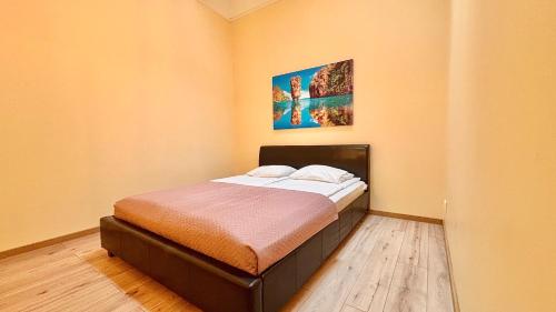 a small bed in a room with a painting on the wall at Kastanimaja Apartments in Tartu