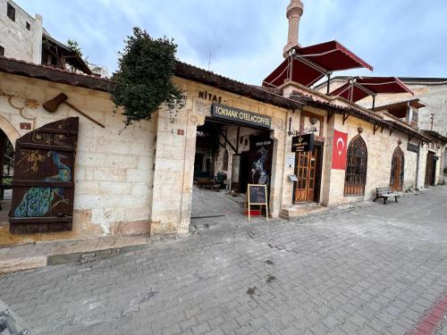 an old brick building with a store on a street at Tokmak Konukevi in Avanos