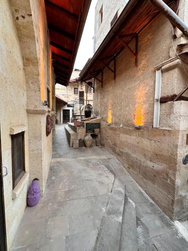 an empty courtyard of a building with a stone wall at Tokmak Konukevi in Avanos