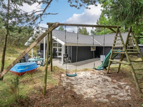 um parque infantil em frente a uma casa em Holiday Home Jannick - all inclusive - 1-5km from the sea by Interhome em Blåvand