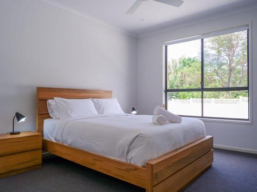 a bedroom with a large bed and a window at Amazing House Big Swimming Pool BBQ in Mooloolah
