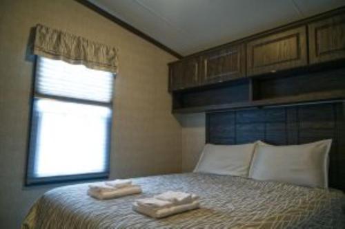 Un dormitorio con dos toallas en una cama con ventana. en 3 Bedroom Waterfront Cottage 12, en Roseneath