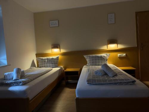 2 Betten in einem Zimmer mit Wandbeleuchtung in der Unterkunft Gasthaus Hecht in Orsingen-Nenzingen